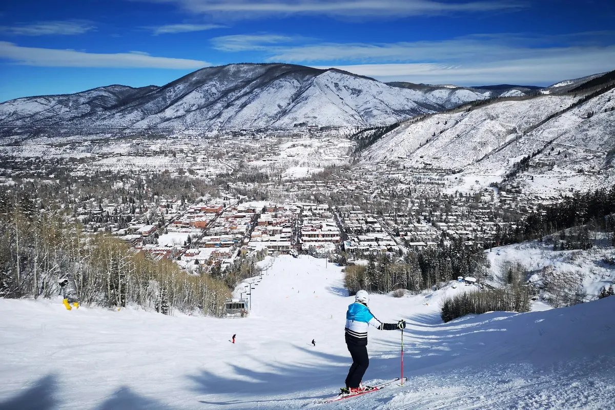A skier above the town of Aspen and its valley