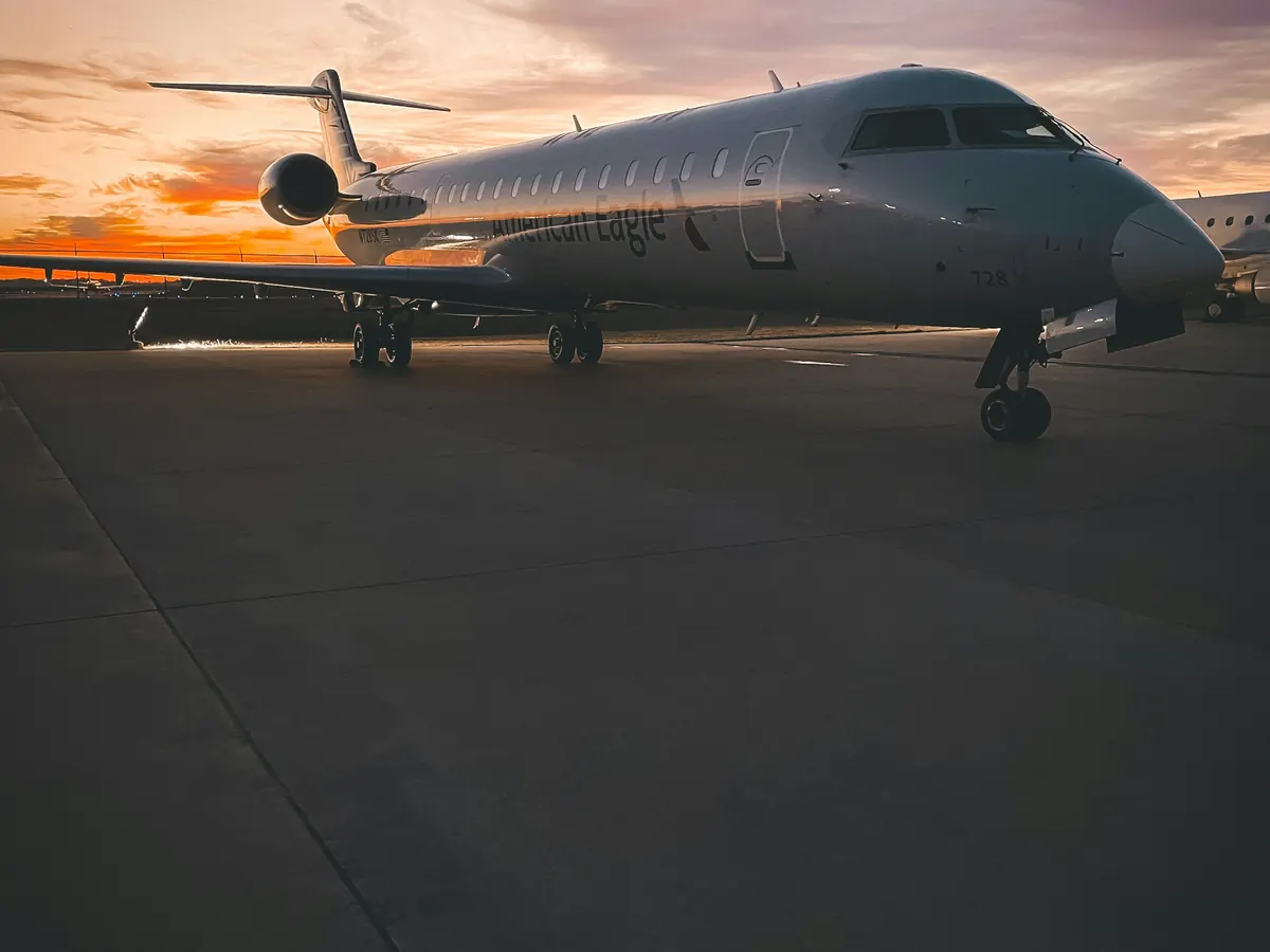 A business jet parked on an empty ramp at dusk