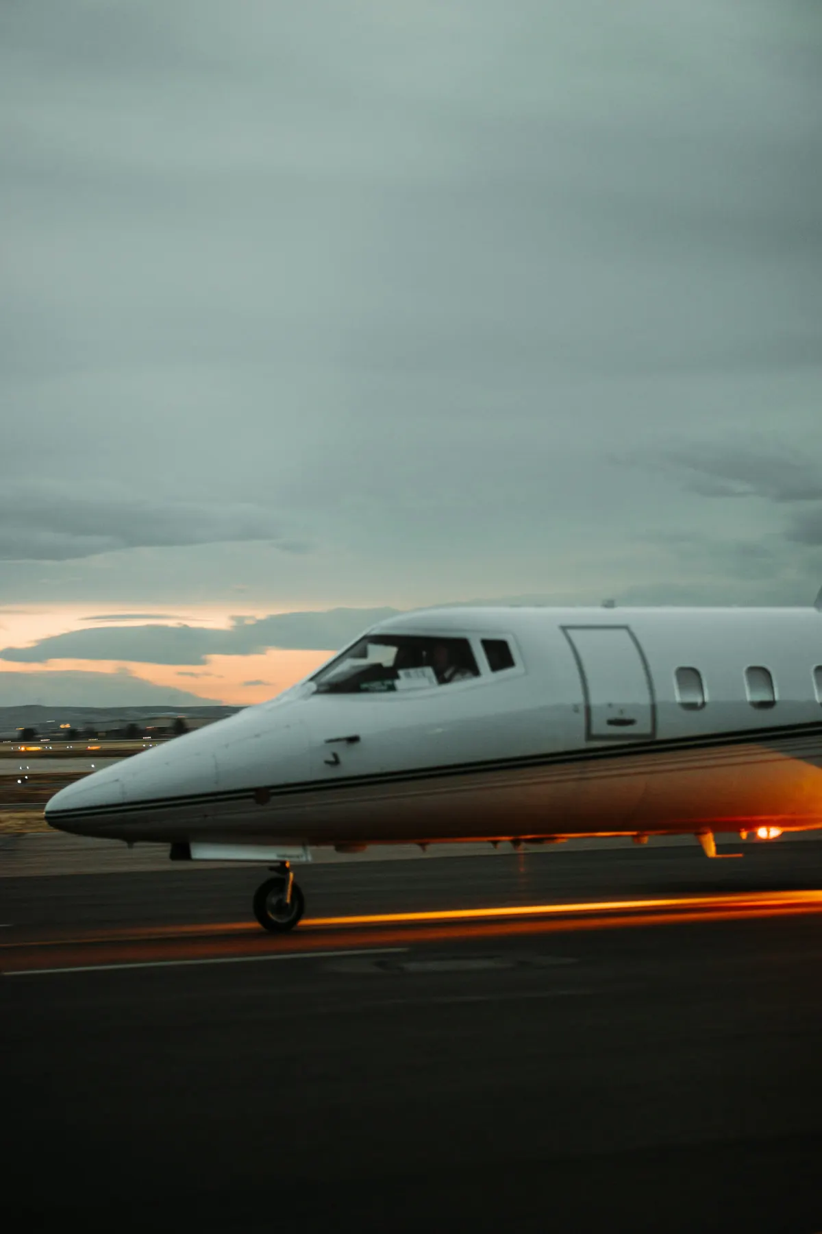 A light business jet waiting on the ramp at dusk