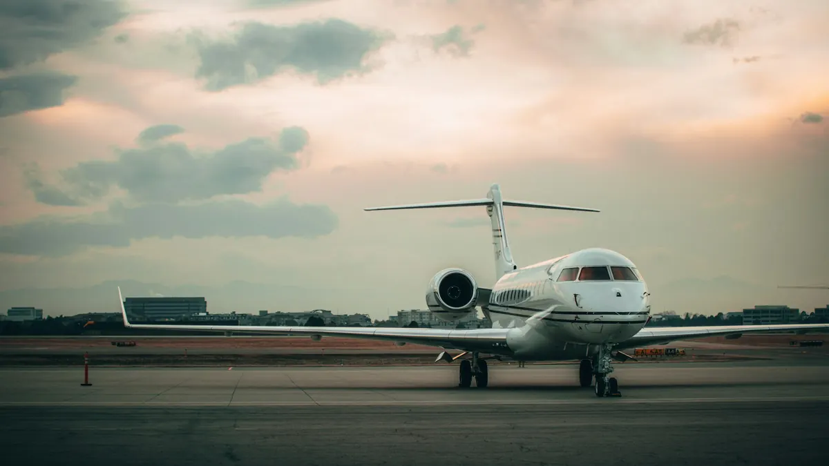 Business jets lined up on a ramp at dusk